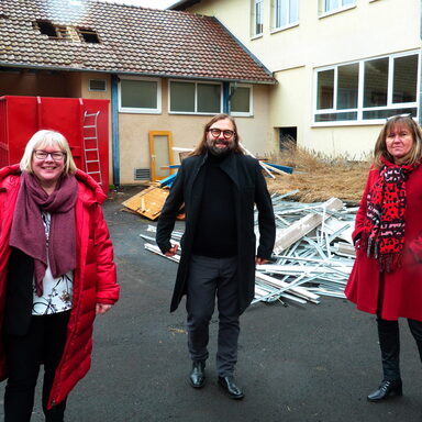 Auf dem Foto sieht man Vizelandrätin Silke Engler, Architekt Frank Ohlmann und die Bundestagsabgeordnete Esther Dilcher vor den abzureißenden Werkstätten