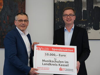 Landrat Andreas Siebert nimmt die Spende der SV SparkassenVersicherung durch Vorstandsmitglied Ralph Eisenhauer entgegen. (v.l.)