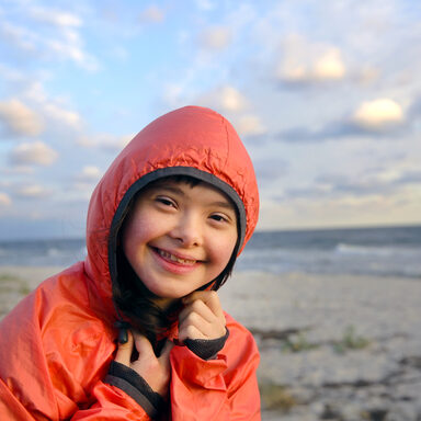 Portrait of down syndrome girl smiling on background of the sea